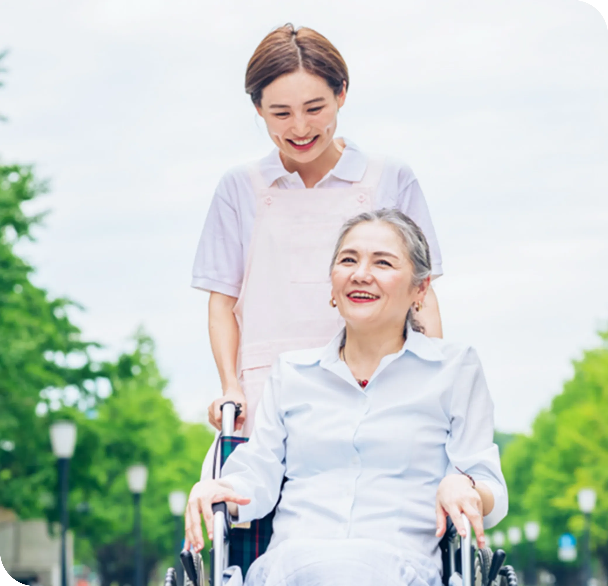 車いすに乗った女性をおす介護者